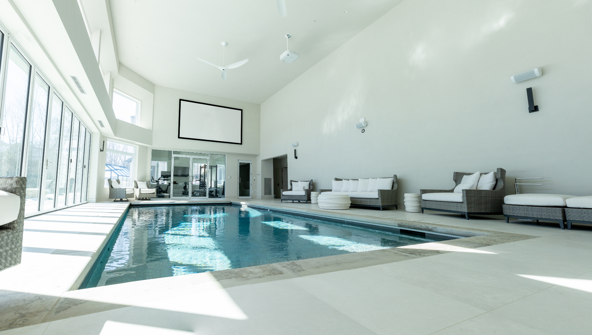 Luxury indoor pool area with projection screen and premium audio system