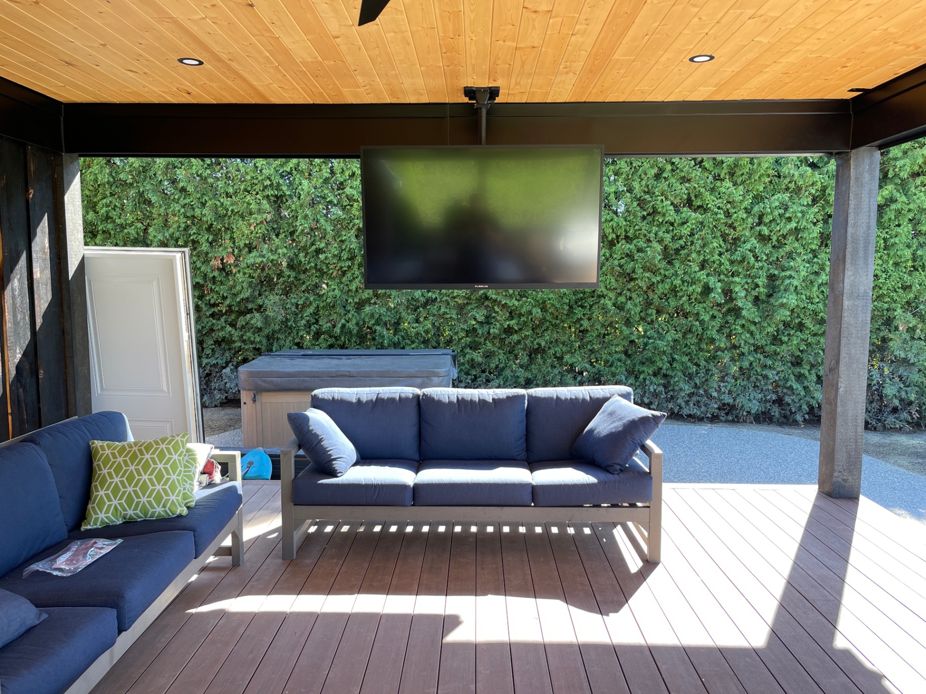 Outdoor entertainment space with weatherproof TV and hot tub integration