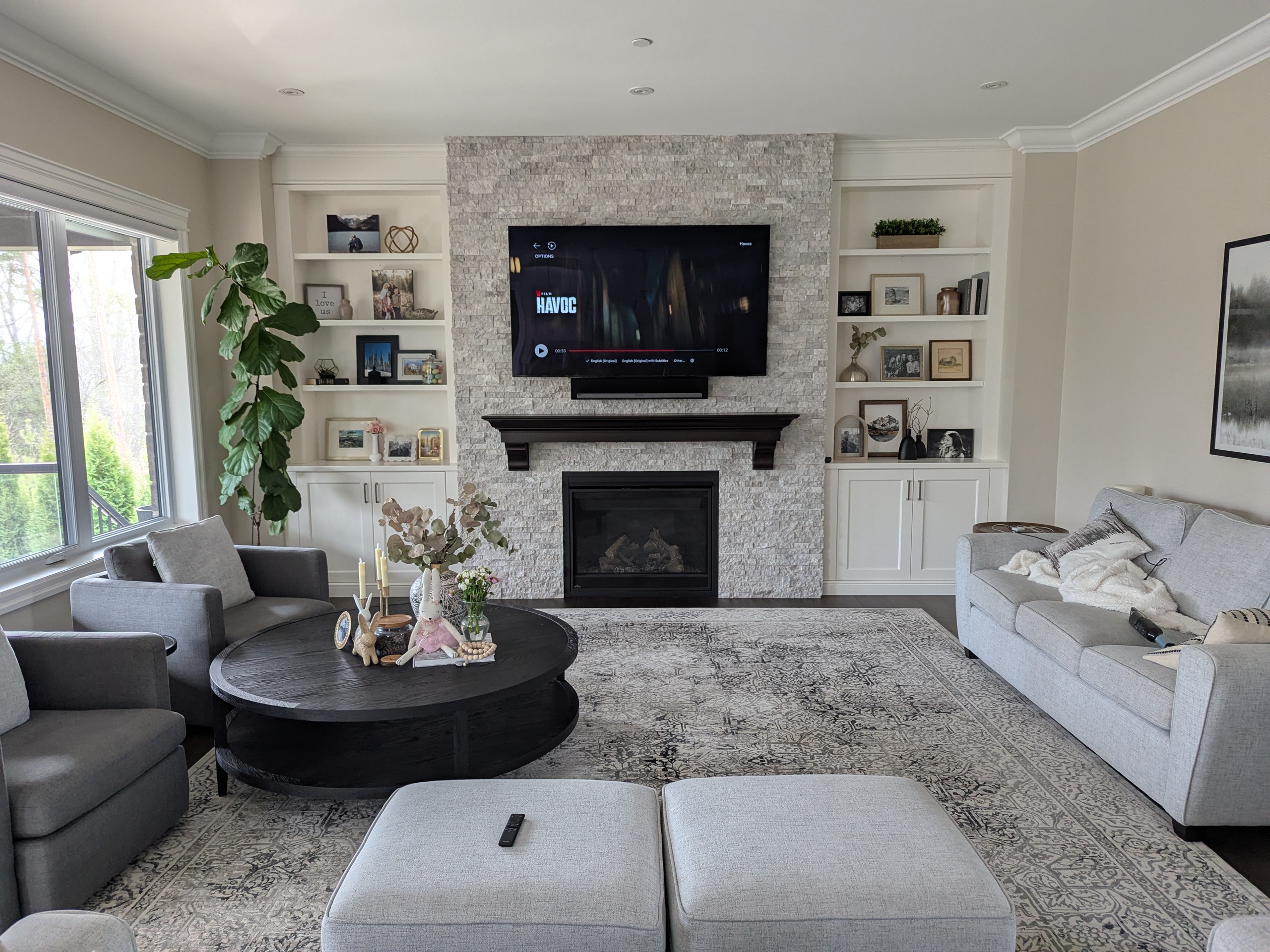 Wall-mounted TV installation with concealed wiring and surround sound speakers